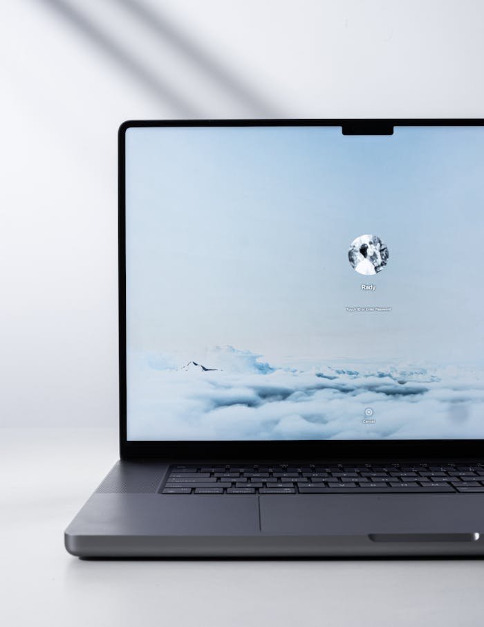 Sleek modern laptop displaying a serene cloud scene on the screen, indoors with natural light.